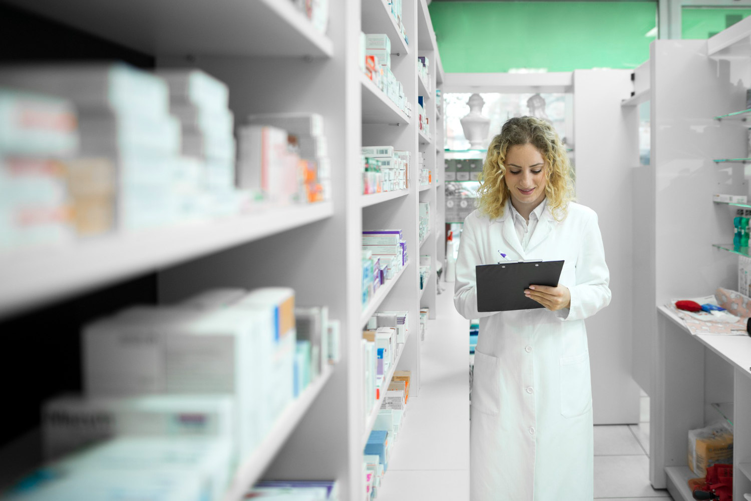 pharmacist-white-uniform-walking-by-shelf-with-medicines-checking-inventory